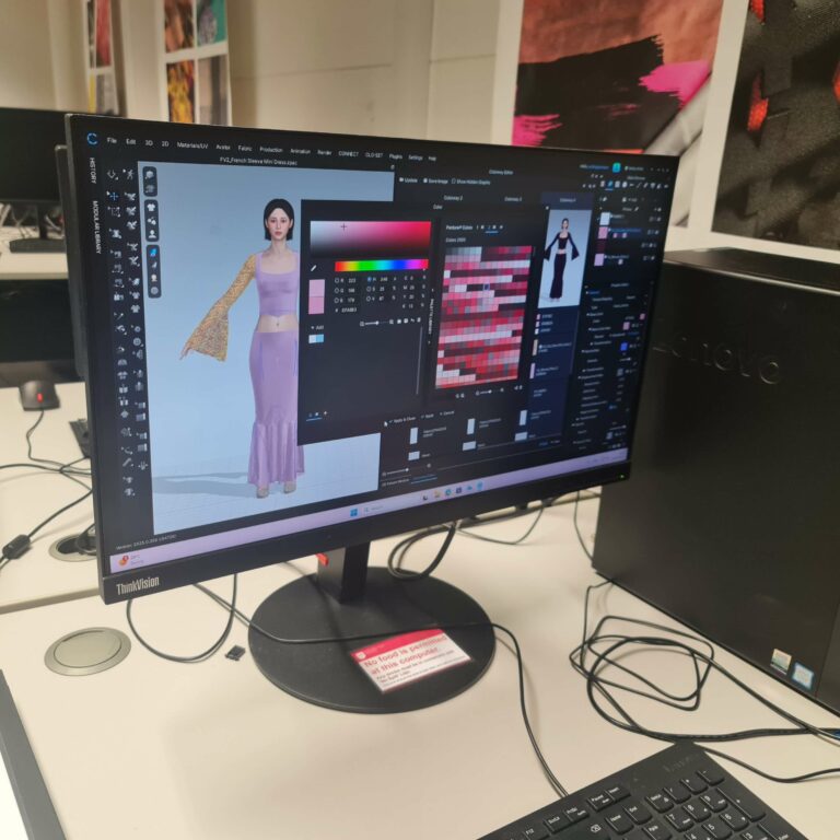 A student learning digital fashion design in CLO3D, adjusting colours and textures on a 3D garment during one of my courses for Nottingham Trent University.